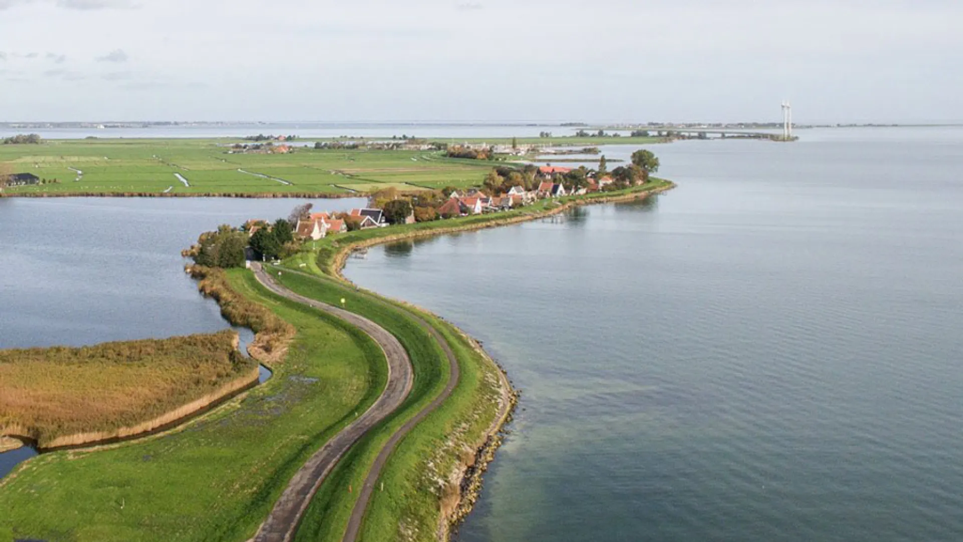 Versterkte dijk met dorp aan het water, gezien vanuit de lucht
